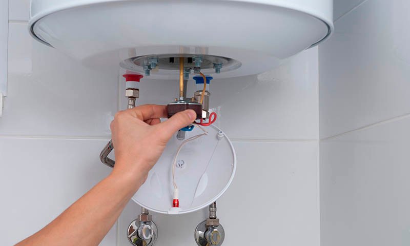 Instalación y mantenimiento de termos eléctricos | Agua caliente eficiente Técnico realizando instalación y ajuste de termo eléctrico doméstico